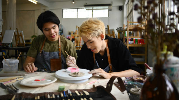 istock Joyful young asian man are creating handmade ceramics, shaping and decorating pottery in workshop. 1539496592