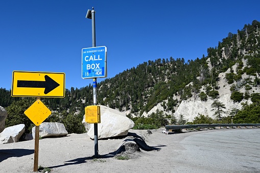 Warning arrow and call box in the San Bernardino Mountains.