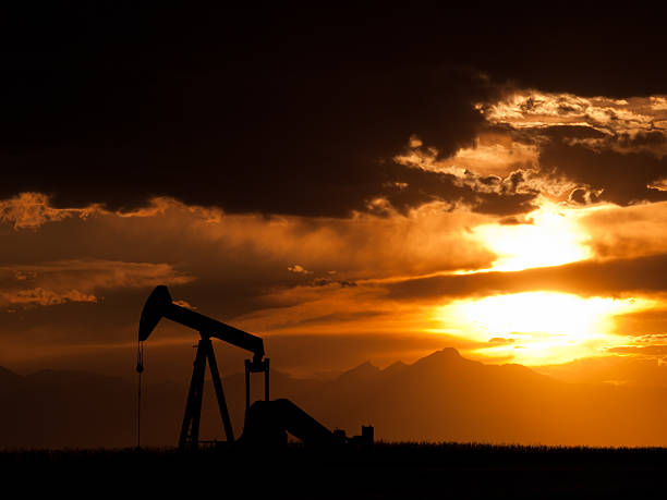 Pumpjack A pumpjack silhoutte with dramatic sunset. goldco prices stock pictures, royalty-free photos & images