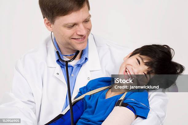 Doctor Laughing With Injured Little Boy During Checkup Stock Photo - Download Image Now