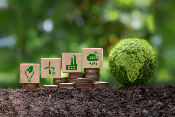 istock Carbon credit and CO2 emission reduction concept. Wooden cubes with CO2 icon on stack of silver coins and green globe with world map. Tax credits for enterprises to stop global warming process. 1539573699