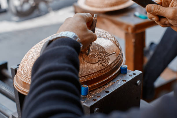 Craftsman doing engravings on a copper metal plate
