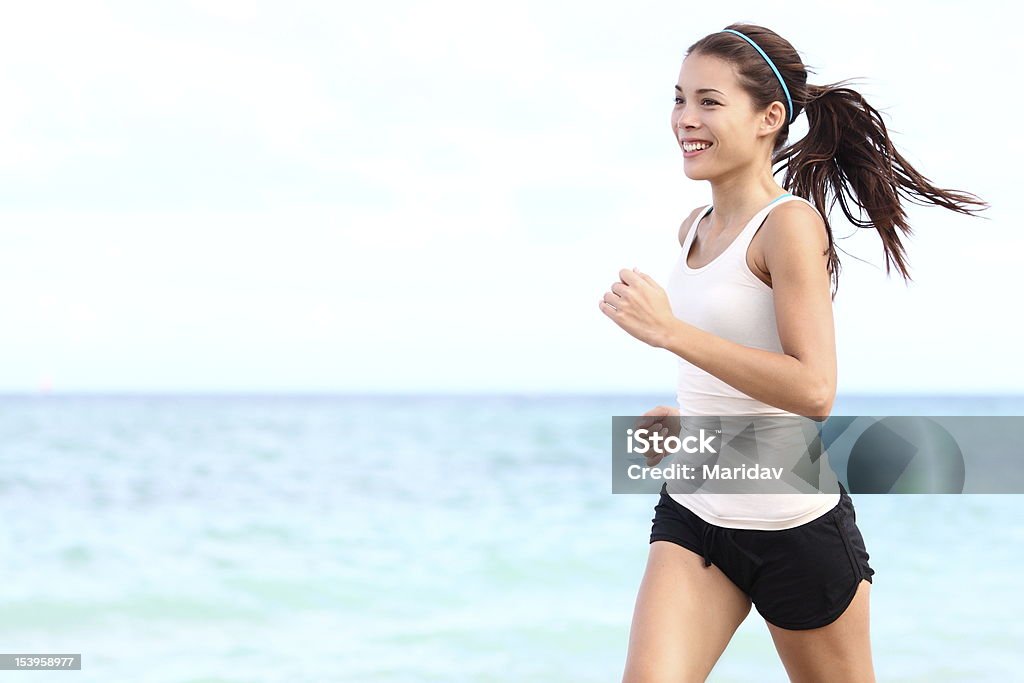 Running woman Running woman. Female runner jogging during outdoor workout on beach. Beautiful fit mixed race Fitness model outdoors. Running Stock Photo