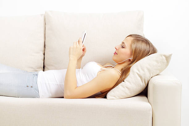 istock Woman Laying on a White Couch Looking at a Smartphone 153959030