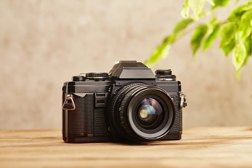 SLR Single-lens reflex professional camera on wooden table