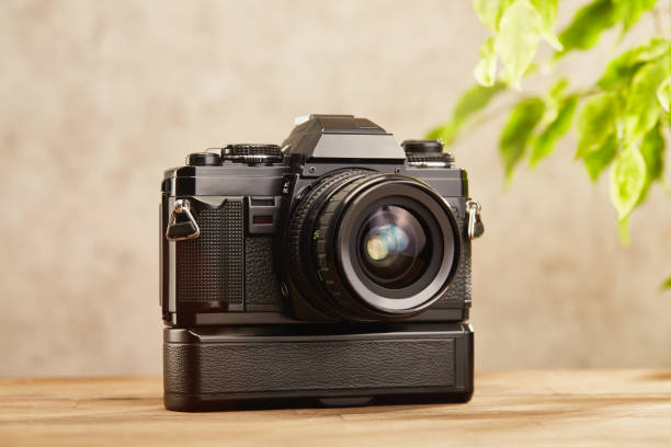 istock SLR Single-lens reflex professional camera with power winder on wooden table 1539613059