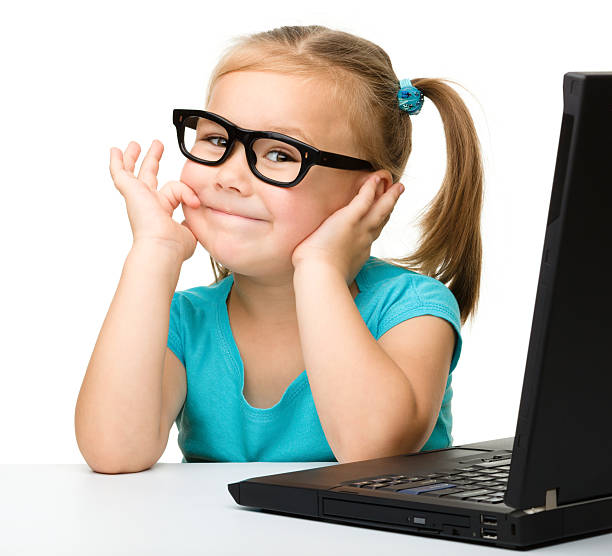 Little girl wearing glasses with a laptop stock photo