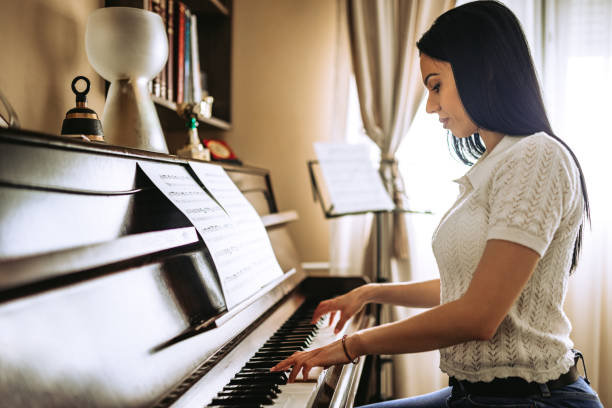 istock Young Woman Playing A Piano At Home 1539628536
