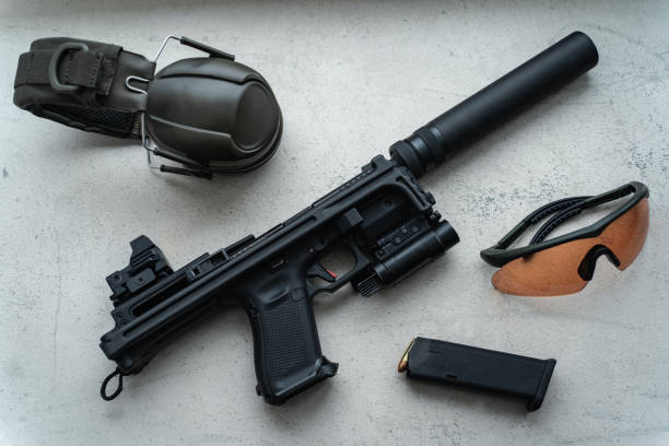 istock Modern weapons. Tactical pistol with folding stock and red dot sight, goggles and earmuffs. 1539629056