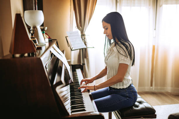 istock Young Woman Playing A Piano At Home 1539631325