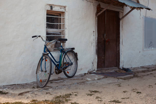 zabytkowy rower przed starym budynkiem - bicycle wall green single object zdjęcia i obrazy z banku zdjęć