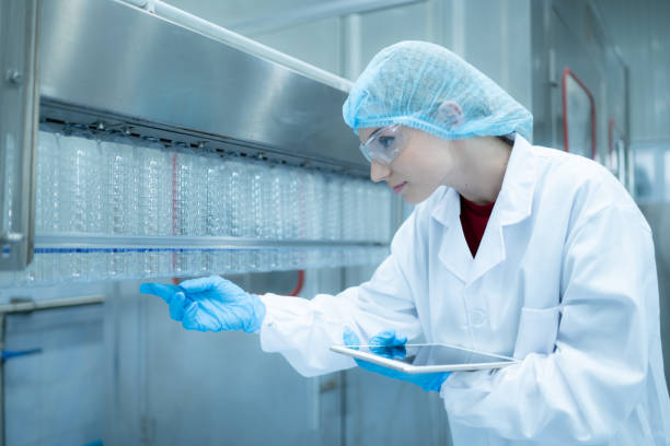 istock Female quality control worker inspecting water bottle on production line in drinking water factory 1539728295