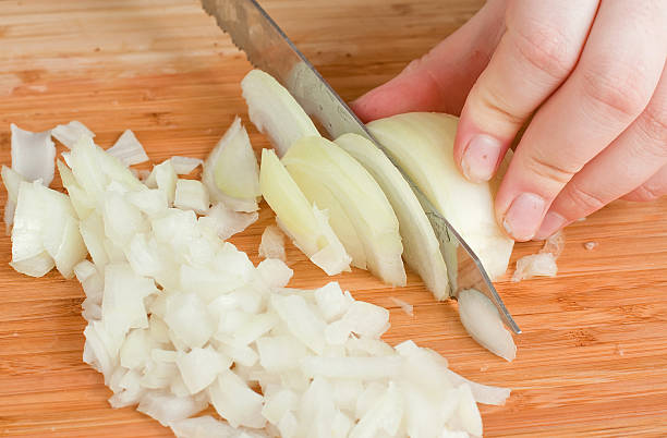 Hands, Cutting Onions The hands cutting onions on a chopping board onion family stock pictures, royalty-free photos & images