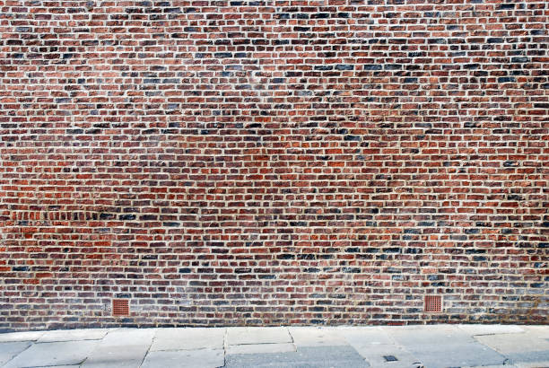 istock Urban background UK - Red brick wall with sidewalk 153974598