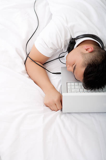 asiatischen mann schlafen mit kopfhörer im schlafzimmer - internet dating audio stock-fotos und bilder