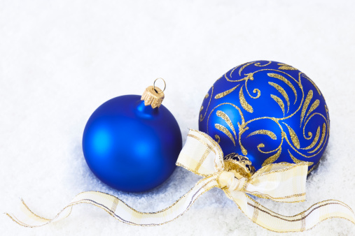 christmas bauble with ribbon in the snow on white background