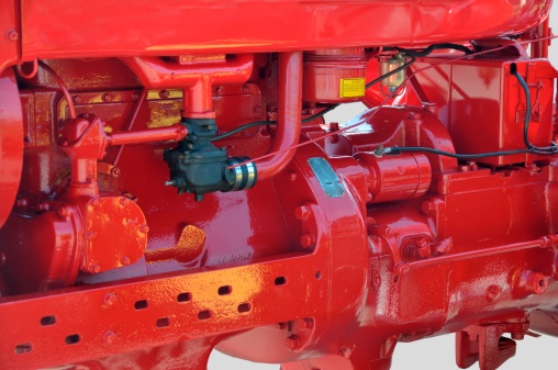 Vintage red tractor engine in rural Georgia, USA.