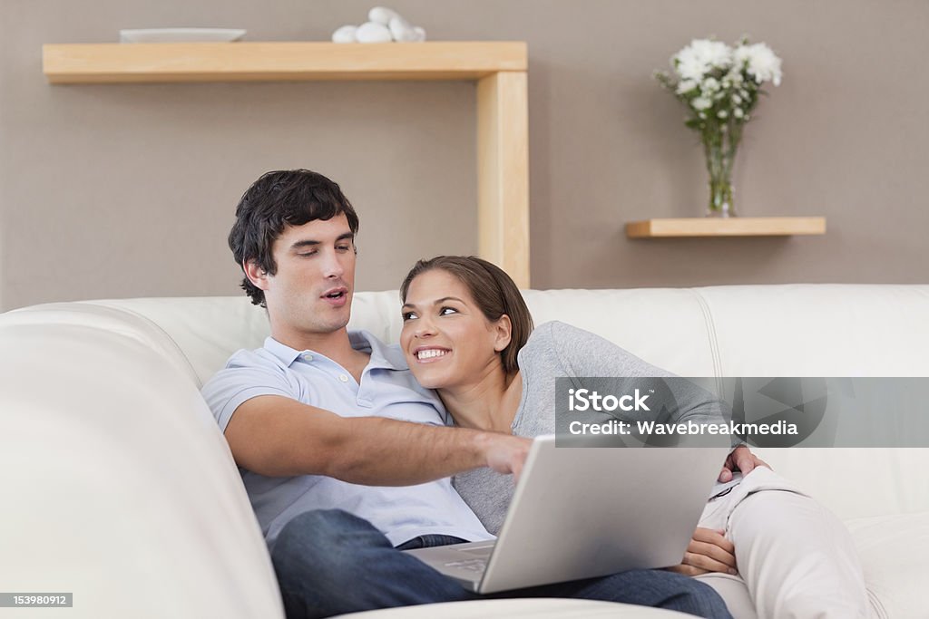 Pareja con su computadora portátil en el sofá - Foto de stock de Adulto libre de derechos
