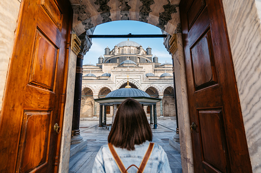 Young woman standing at the entrance of Bayezid II Mosque in Istanbul, Turkey.
