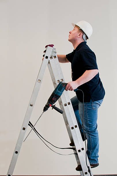 istock man enters the ladder with drill 153981219