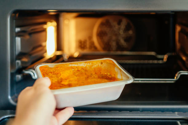 Man putting ready meal in the microwave oven at home