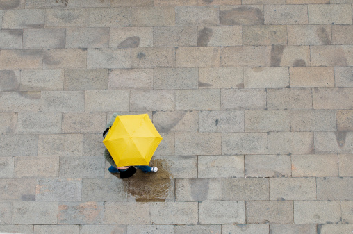 Two people shelter under an umbrella in Venice.
