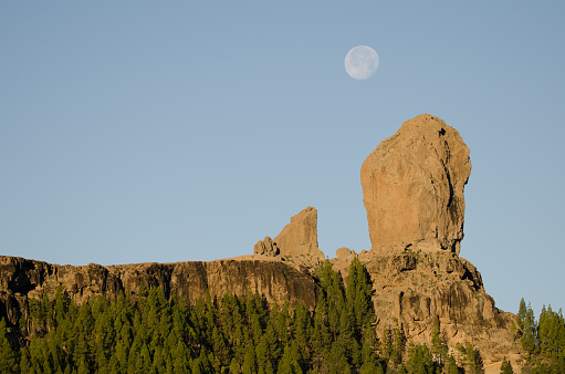 Roque Nublo to the right, La Rana to the left and full moon. The Nublo Natural Monument. Tejeda. Gran Canaria. Canary Islands. Spain.