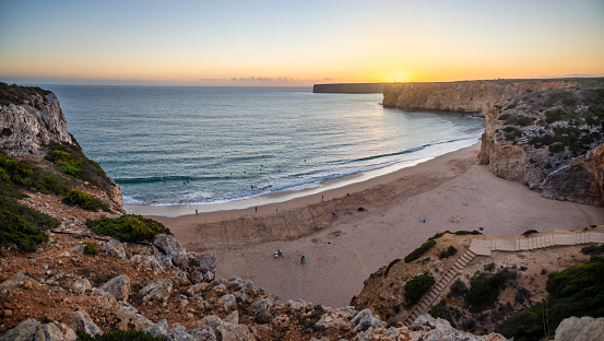 Praia do Beliche with Lighthouse of Cabo Sao Vicente in the background at sunset. Praia do Beliche is located between the tip of Sagres and Cape St. Vincent, Albufeira, Portugal.