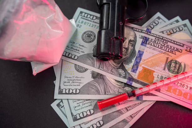des paquets de drogues en poudre et des billets d’un dollar à côté d’un couteau, d’une arme à feu et d’une seringue médicale. - narcotic gun medicine currency photos et images de collection