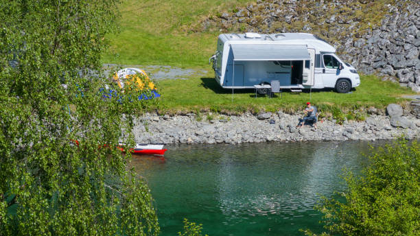 istock Riverfront RV Camper Van Camping with Tent and Kayaks 1539860465