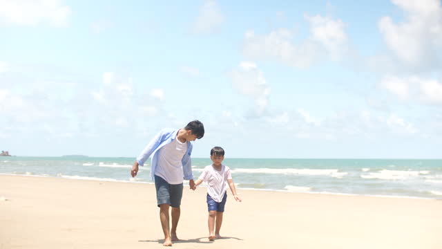 Happy Father And Son Having Fun On The Beach In Summer Day