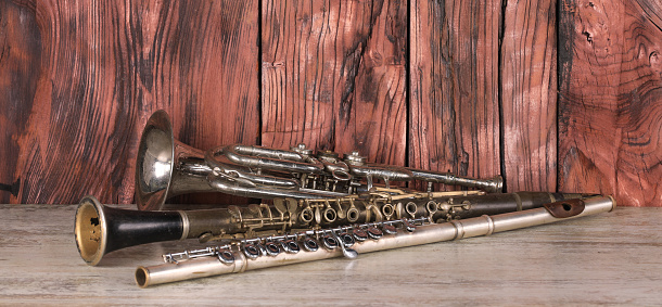 horn, clarinet and flute on a wooden table