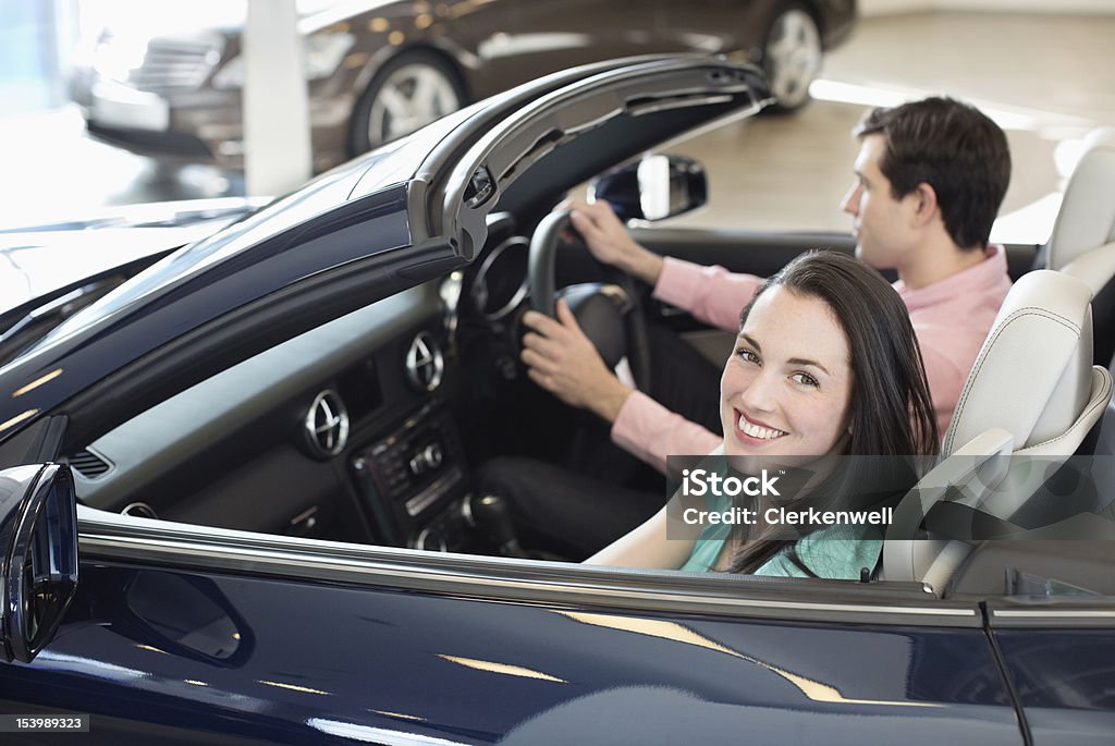 Портрет улыбающегося женщина с человеком в Кабриолет на автомобиль дилеры - Стоковые фото 25-29 лет роялти-фри