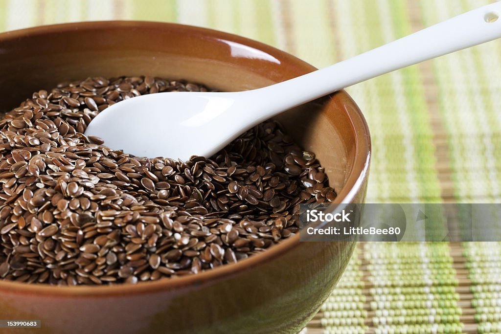 Flax seed Brown flax seeds in brown green bowl with a white ceramic spoon Acid Stock Photo