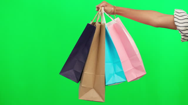 Shopping bag in hand, retail and green screen, product and boutique discount isolated on studio background. Customer with purchase, person buying and store sale with mockup space and commerce