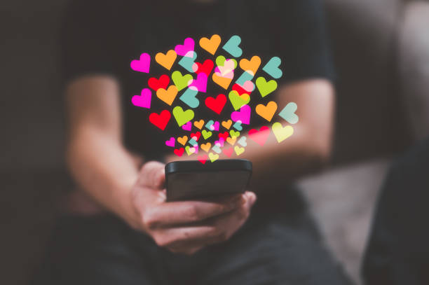 istock Social media concept. Hands with smartphone and like notification icon. Social networking, man using smartphone sending hearts icon on application internet network 1539954722