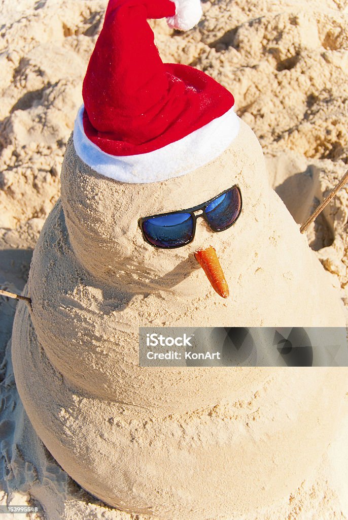 Sand Snowman on warm beach at christmas eve Birds Eye View On Snowman With sunnglasses and carrot nose on beach Christmas In July Stock Photo