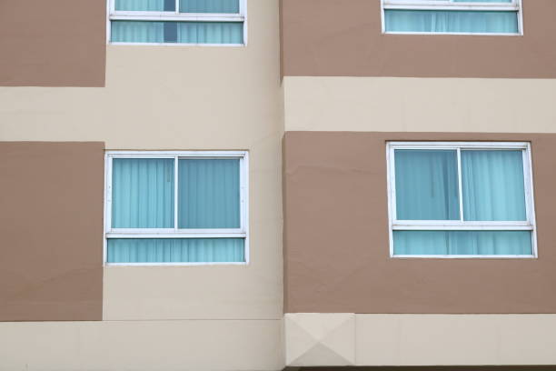 Aluminium frame and glass window of brown painted building with curtain inside.