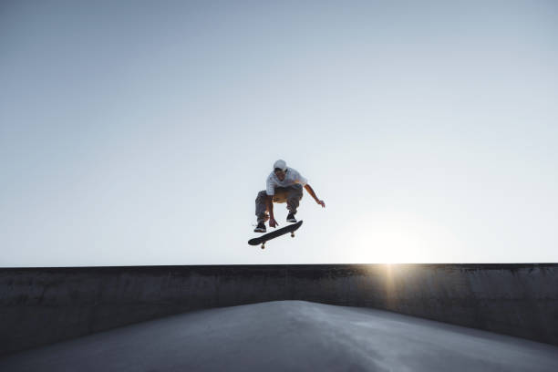 Skater doing kickflip on the ramp at skate park - Stylish skaterboy training outside - Extreme sport life style concept Skater doing kickflip on the ramp at skate park - Stylish skaterboy training outside - Extreme sport life style concept skateboard stock pictures, royalty-free photos & images