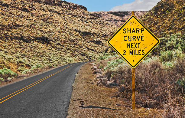 istock Sharp Curve Next 2 Miles Sign With Bullet Holes 153999524