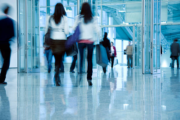 istock Blurred People Walking Through Corridor Towards Glass Doors 153999603