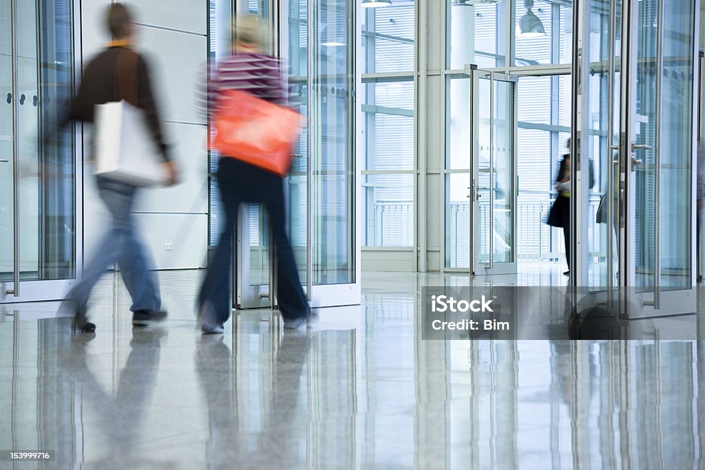 Duas mulheres jovens com sacos de compras a caminhar através da porta - Royalty-free Porta Foto de stock