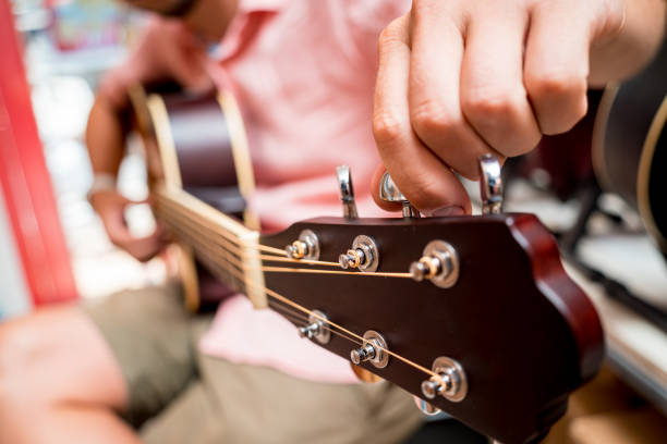 istock Young musician tuning a classical guitar in a guitar shop 1540012896