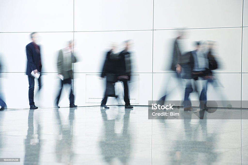 Commuters Walking in Corridor, Blurred Motion people walking in a modern interior, blue toned, long exposure Office Stock Photo
