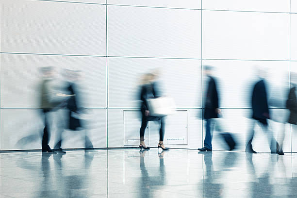 istock Motion Blurred Pedestrians Walking in White Hallway 154002928