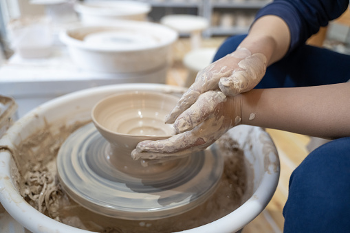 A child is making pottery in a handicraft workshop