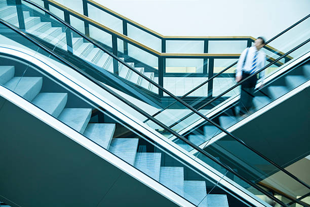 istock Businessman Looking over Shoulder on Escalator, Blurred Motion 154003267