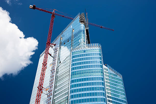 Modern Office Building in Construction, Paris, France high rise commercial office building in construction stage with huge crane, tower crane stock pictures, royalty-free photos & images