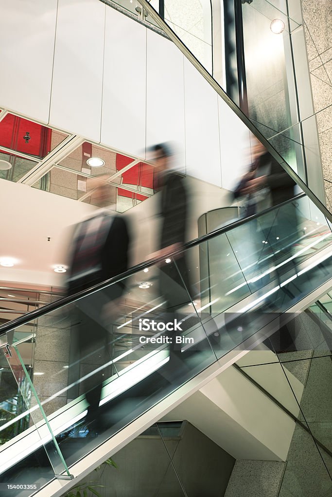 Motion Blurr de los empresarios en escalera mecánica - Foto de stock de Abstracto libre de derechos