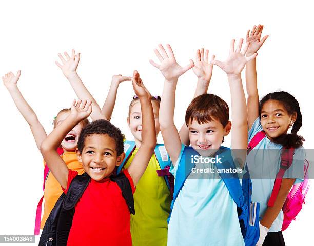 Children With Backpacks Holding Their Hands In The Air Stock Photo - Download Image Now